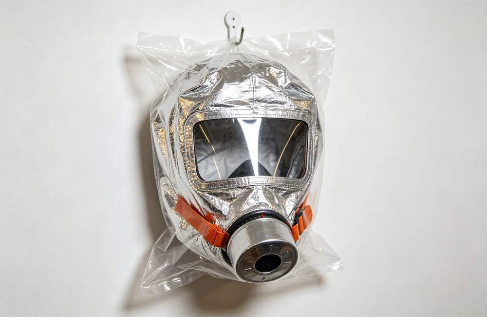 Sealed silver EN403 smoke mask in individual plastic packaging ready for bulk wholesale home fire kit and emergency supply orders today