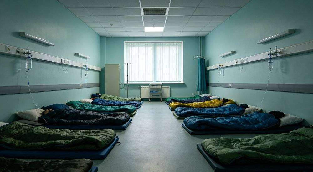 Wide angle view of hospital temporary rest area with sleeping bags for patients and medical staff